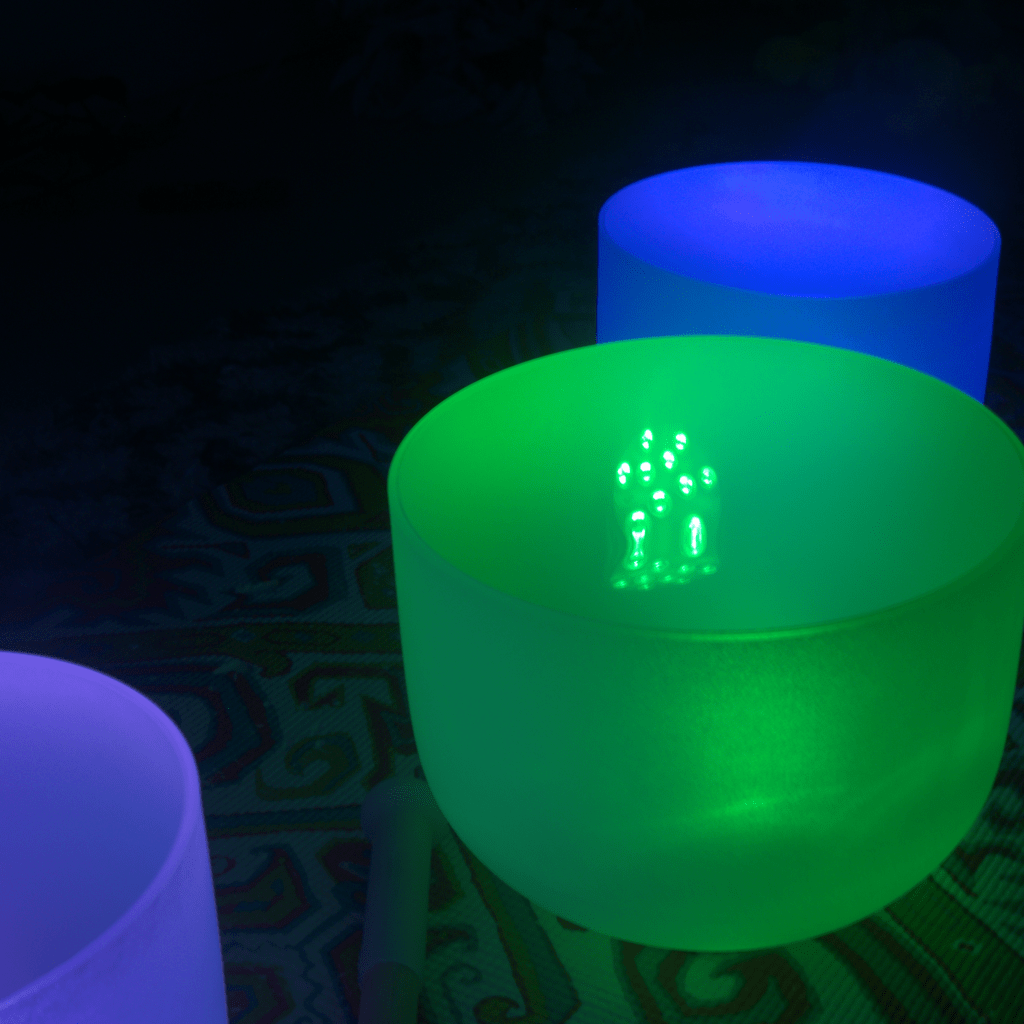 3 quartz singing bowls sitting on yoga mat.
